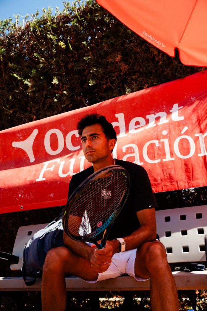 Nicolás sentado en el banquillo con la raqueta